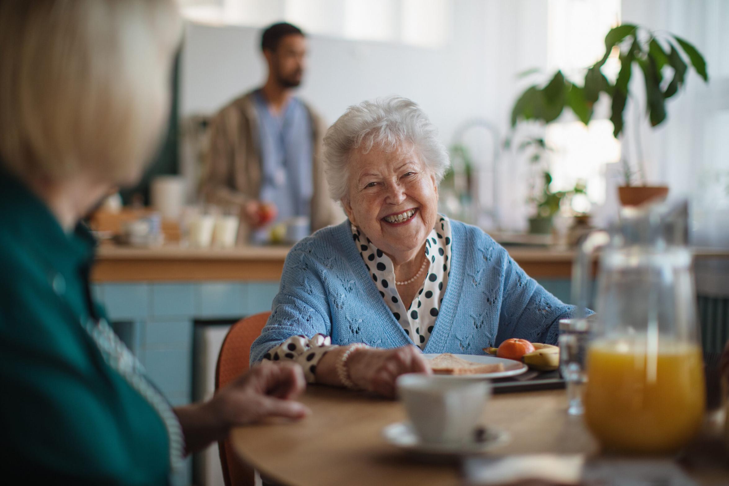 resident sat eating breakfast smiling
