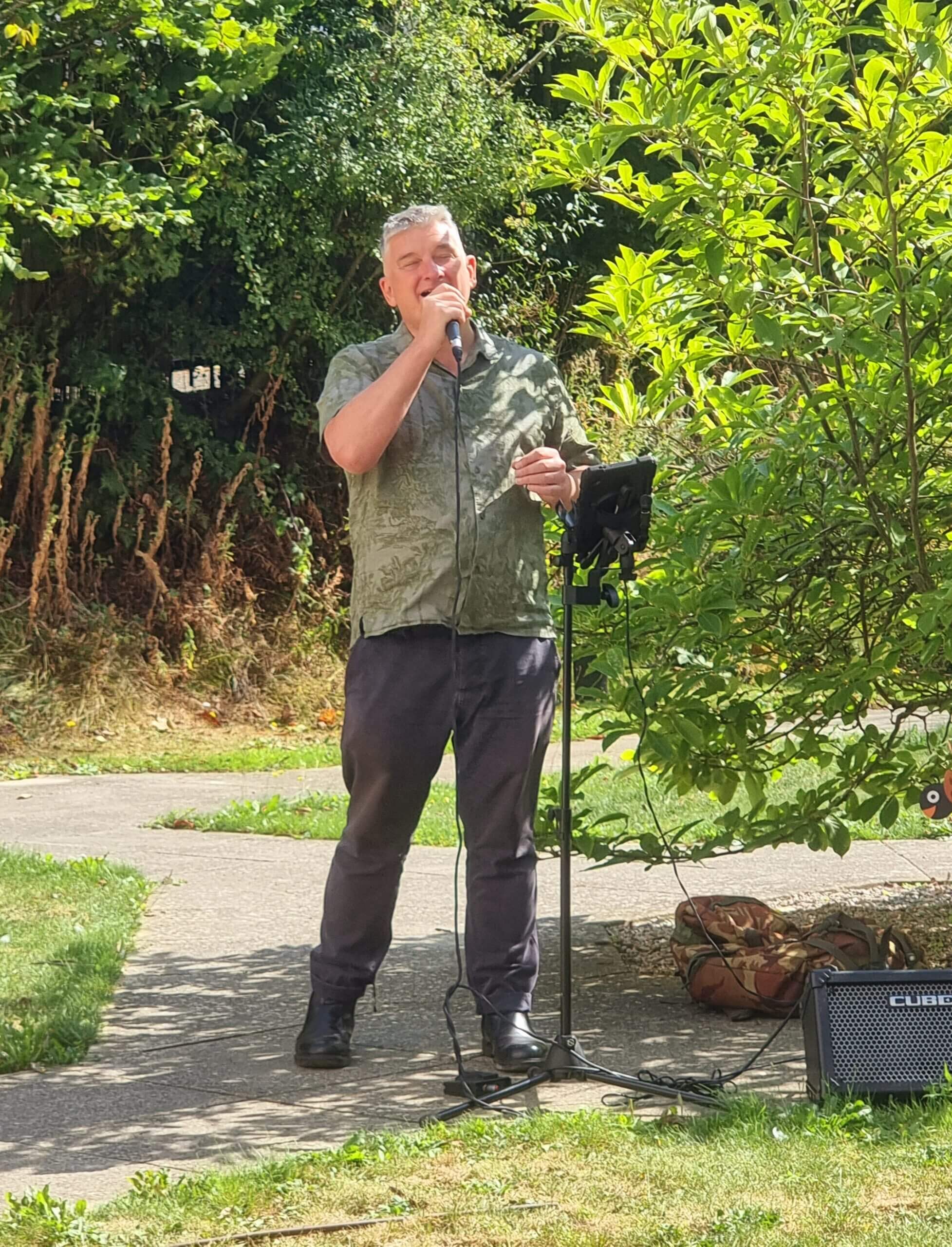An entertainer sings in the garden for residents