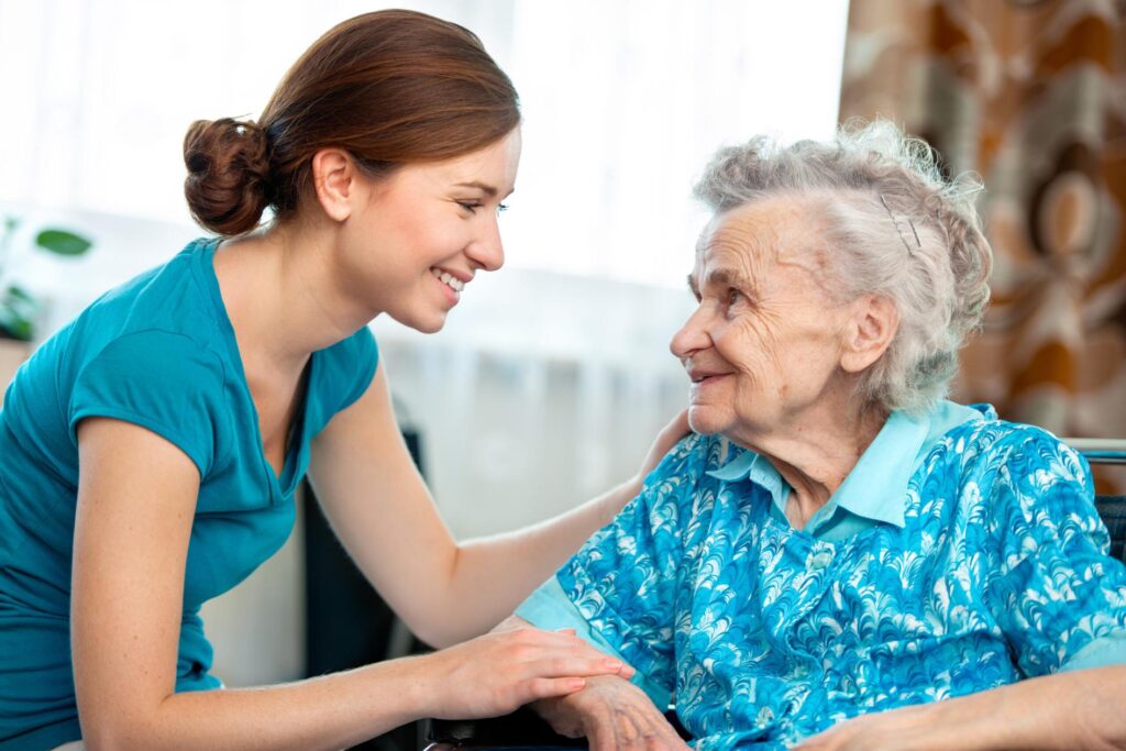 resident sat down with carer smiling at each other