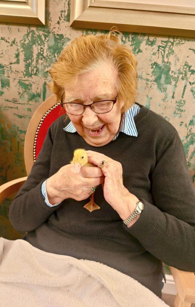 resident smiling holding a duckling