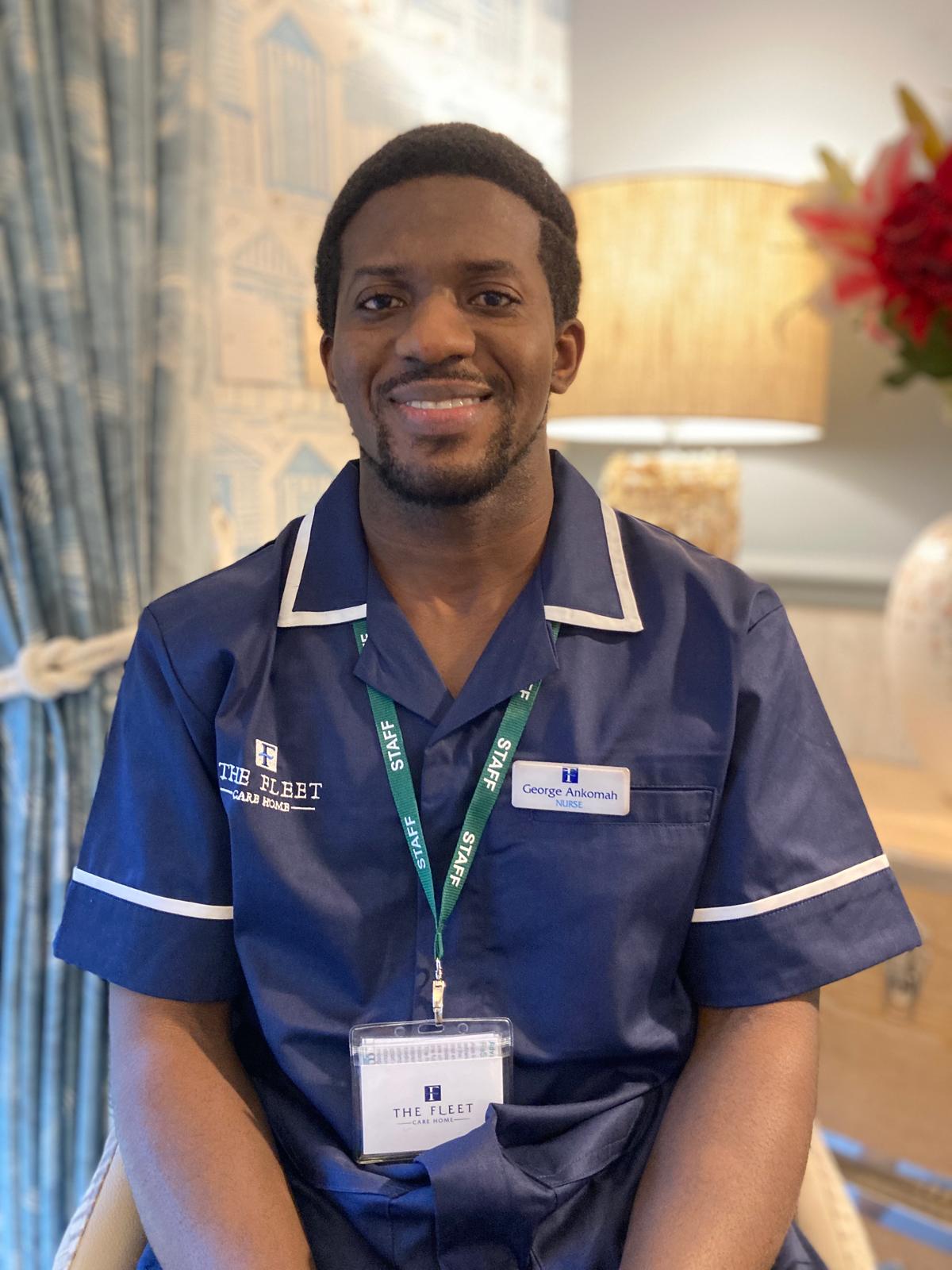 man in nurse uniform smiling at camera for staff photo